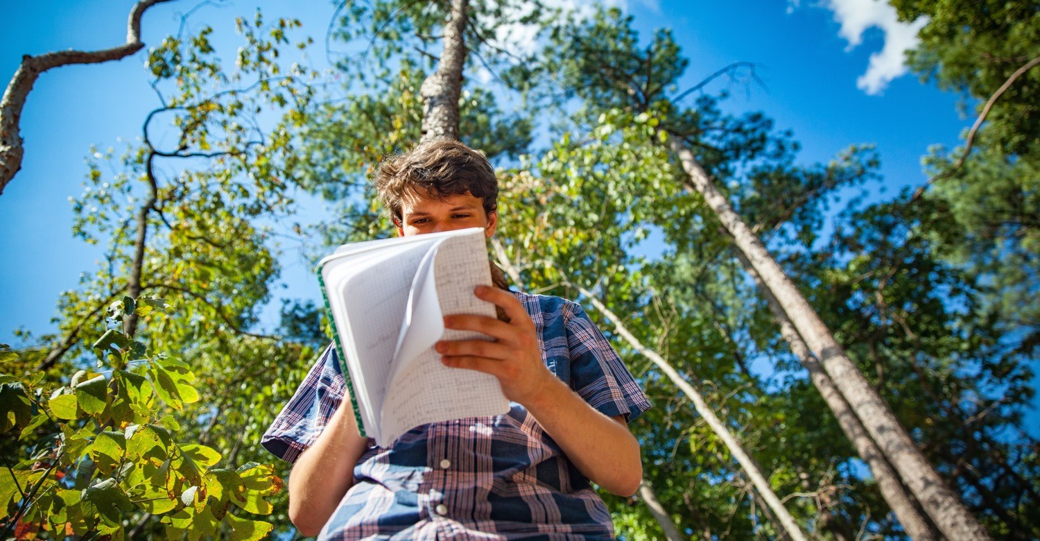 Forestry student Liam Corley, C'20, records tree data during an afternoon lab in Sewanee's Demonstration Forest.