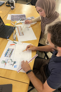 Youth organizers and an architect collaborating on a soccer pitch design.