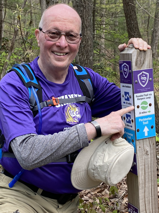 Harper poses by the Harpers Loop sign on Sewanee's Perimeter Trail, which he partially hiked a few years ago. (Don't be fooled&mdash;the loop was named for Harpers Ferry, West Virginia!)