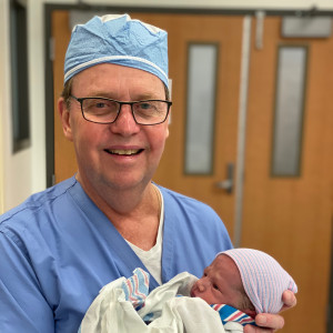 Dr. Mullins with his last baby delivered before retirement